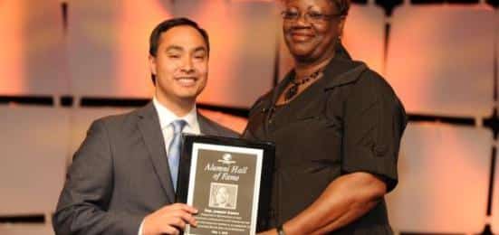 Black woman and latino man holding plaque